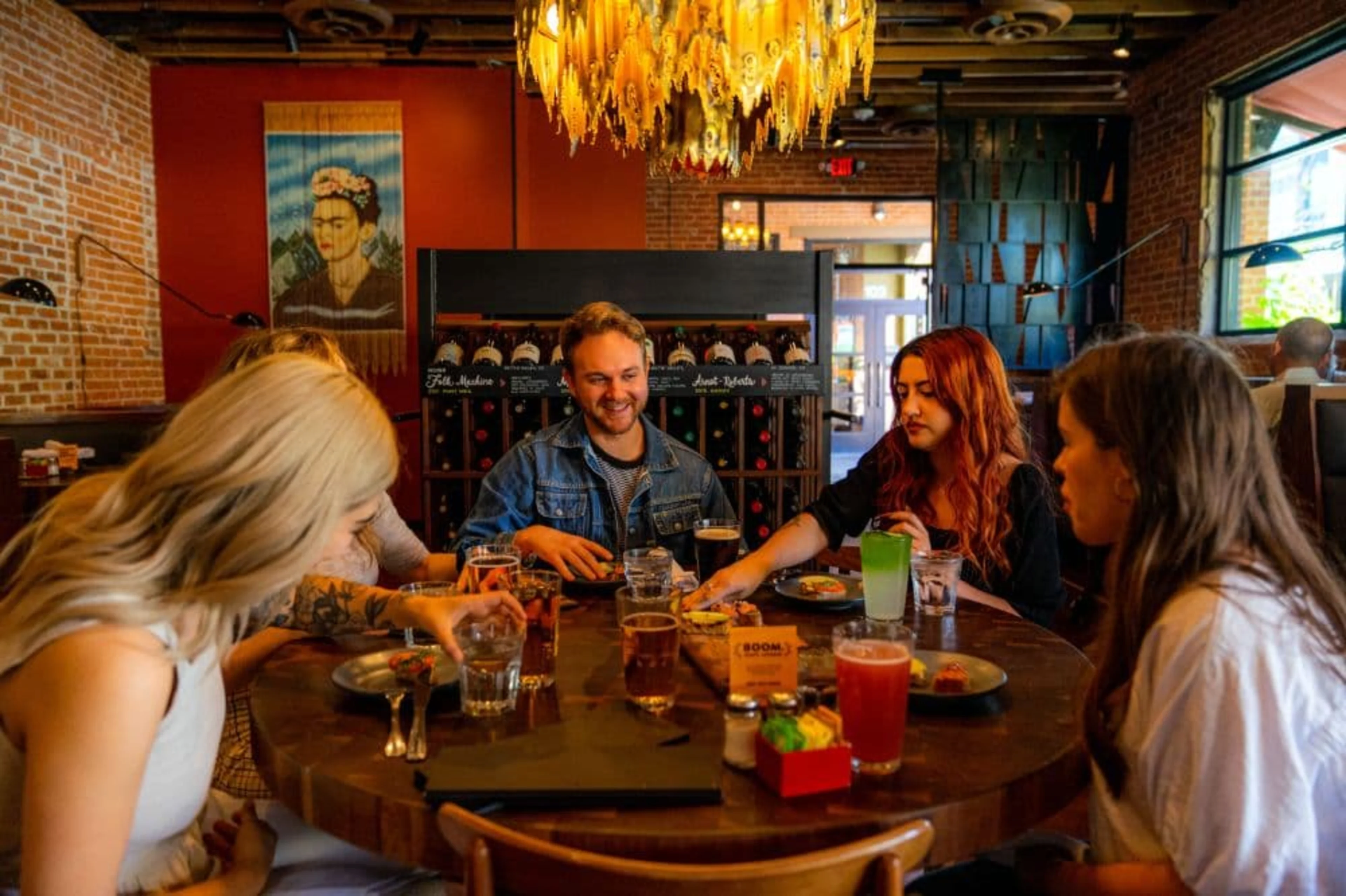 Dimly lit room with a table of people eating and drinking.