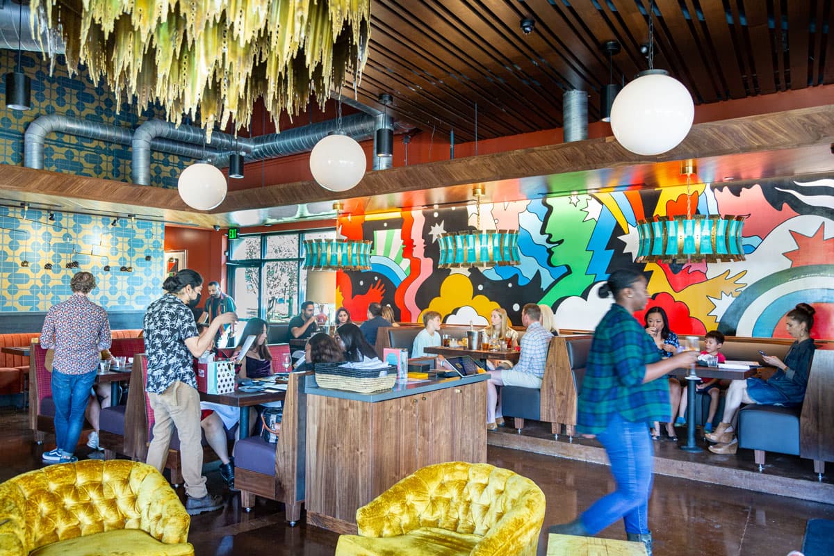 A busy restaurant with staff and customers walking.