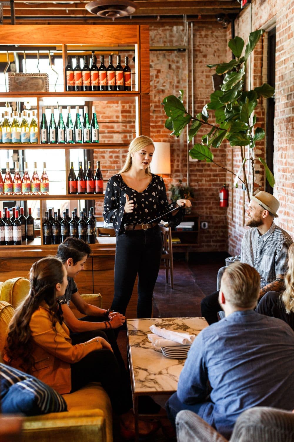 Waitress standing at table explaining the menu to four customers.