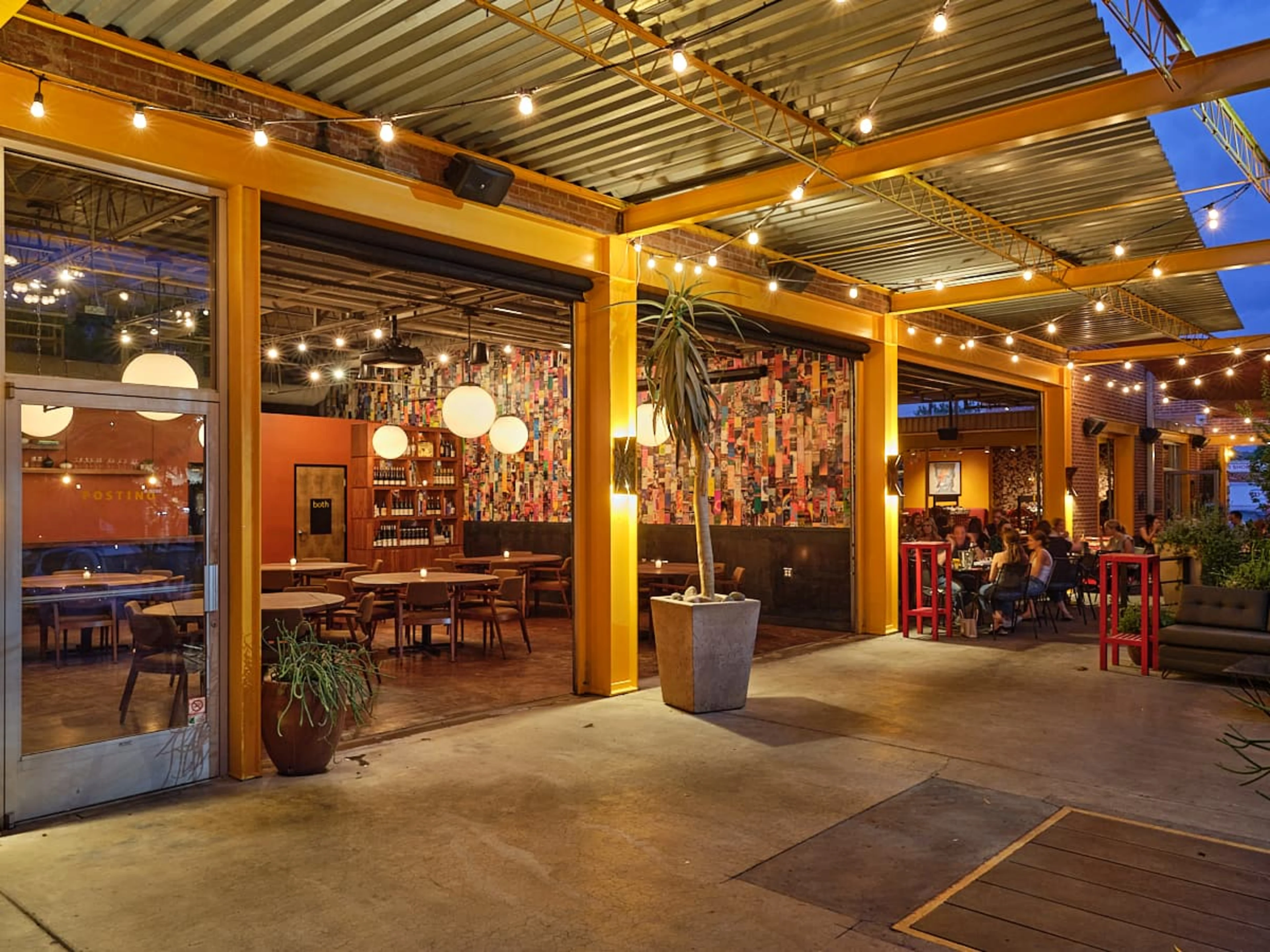 A restaurant with yellow walls and strings of lights.