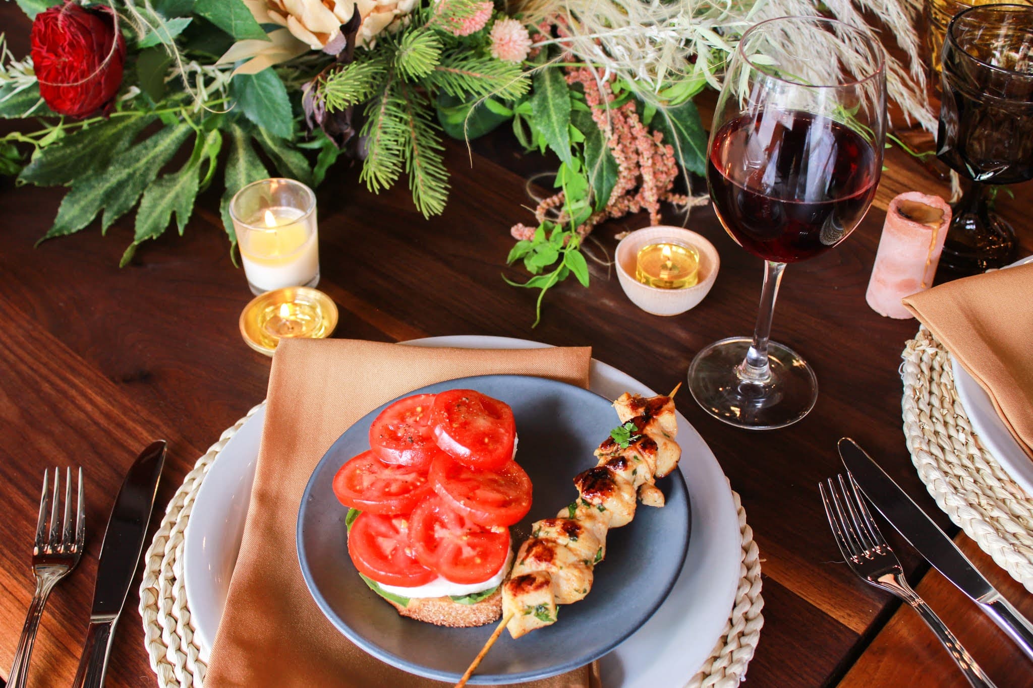 A wooden table set with a plate of bruschetta and a glass of red wine