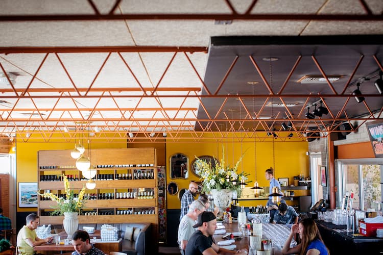 A yellow wall with wine in a restaurant.