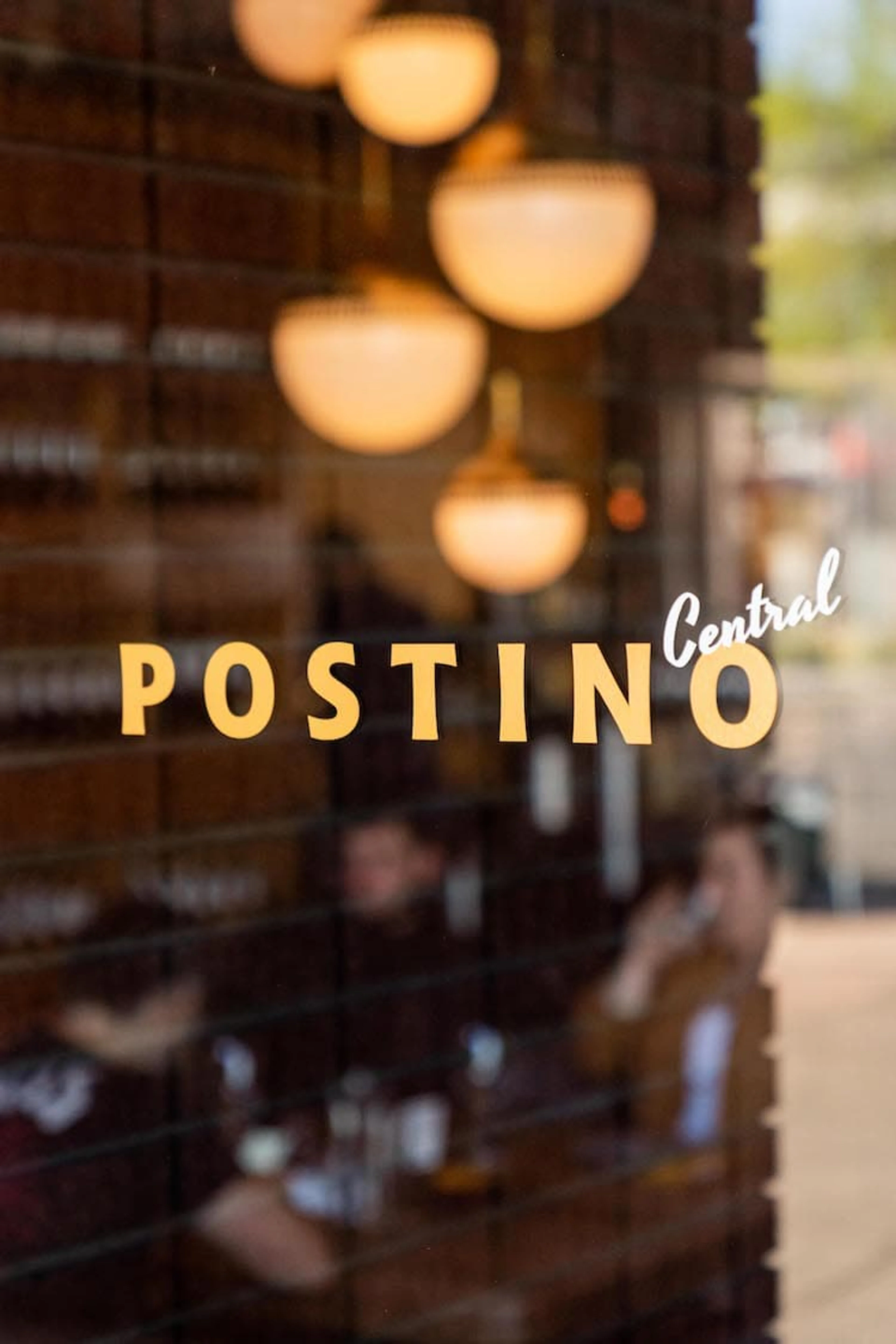 A glass door with the Posinto Central logo in yellow and white.