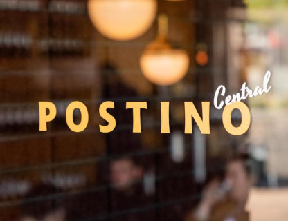 A glass door with the Posinto Central logo in yellow and white.