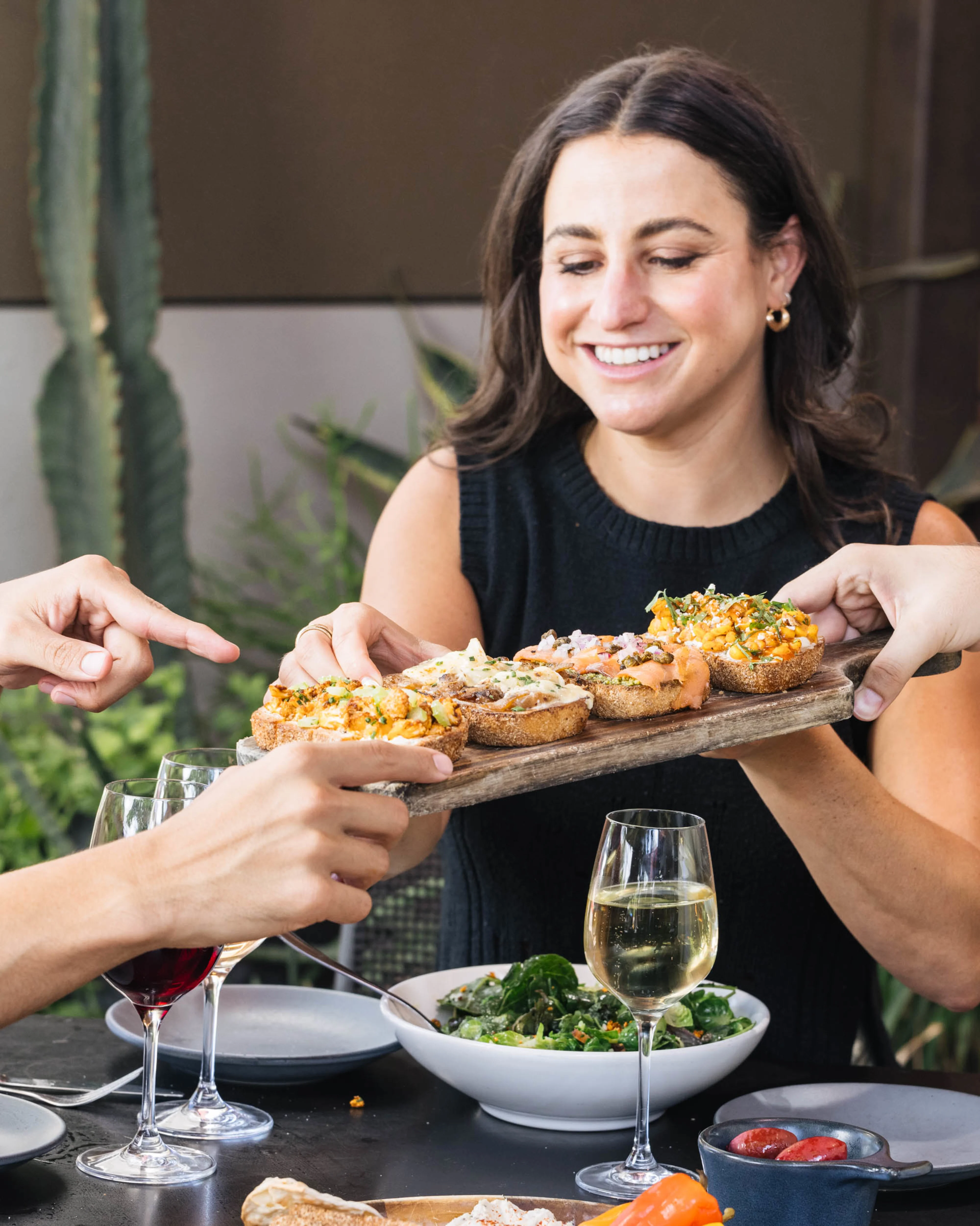 Smiling woman holding a board of bruschetta