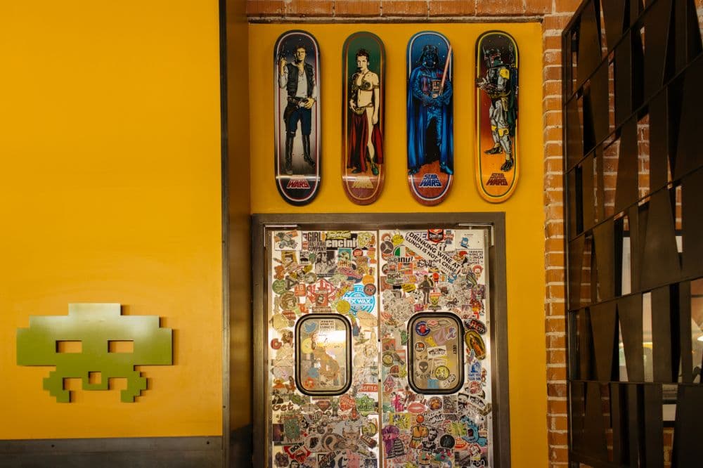 Yellow wall with colorful skateboards.