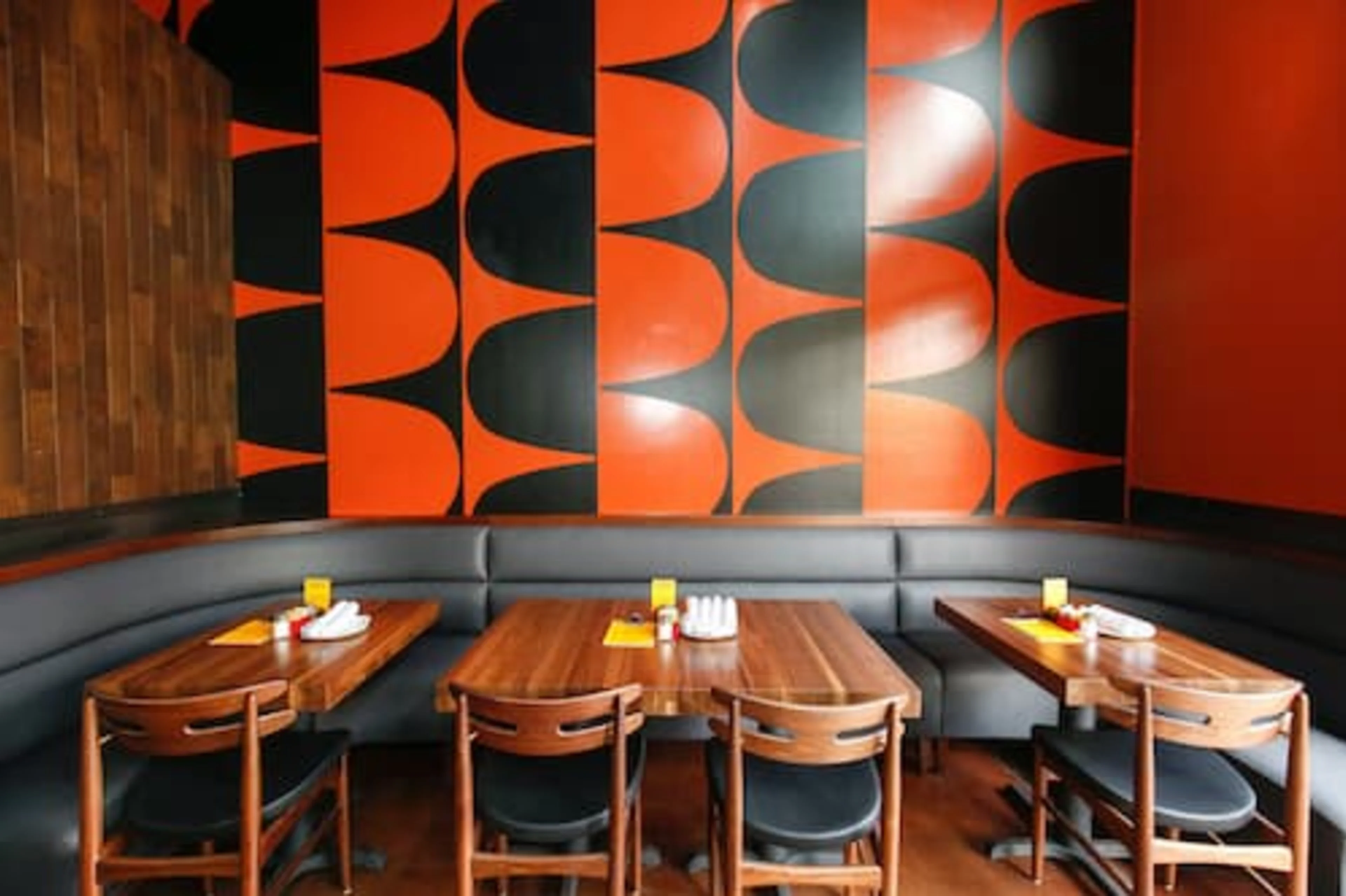 A grey booth with black and white wall art behind it.