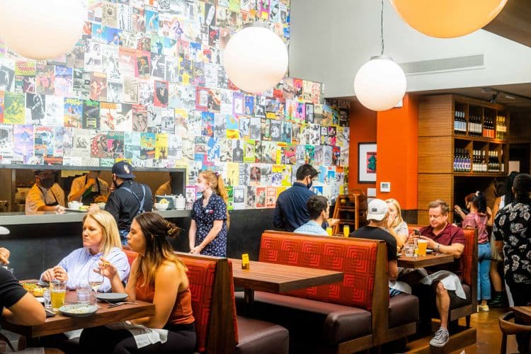 A restaurant with large white globe lights and a colorful wall.