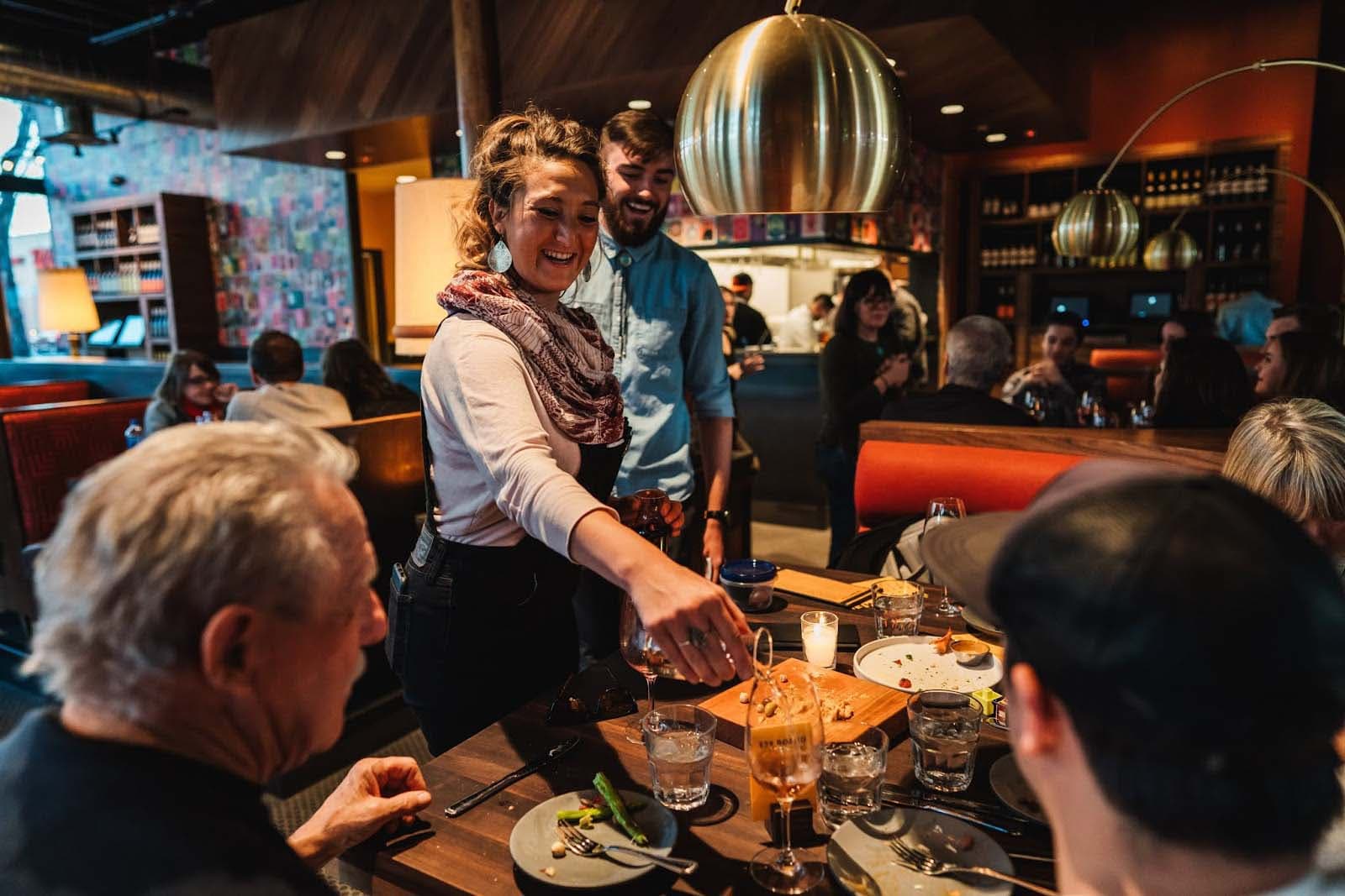 A server pour wine for guests dining
