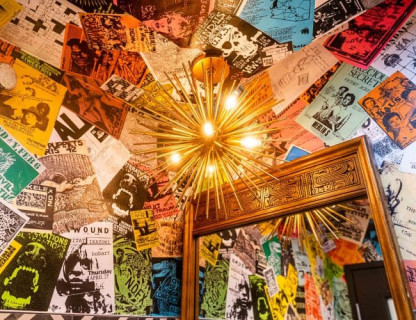 A unique starburst light surrounded by colorful posters and a large mirror.