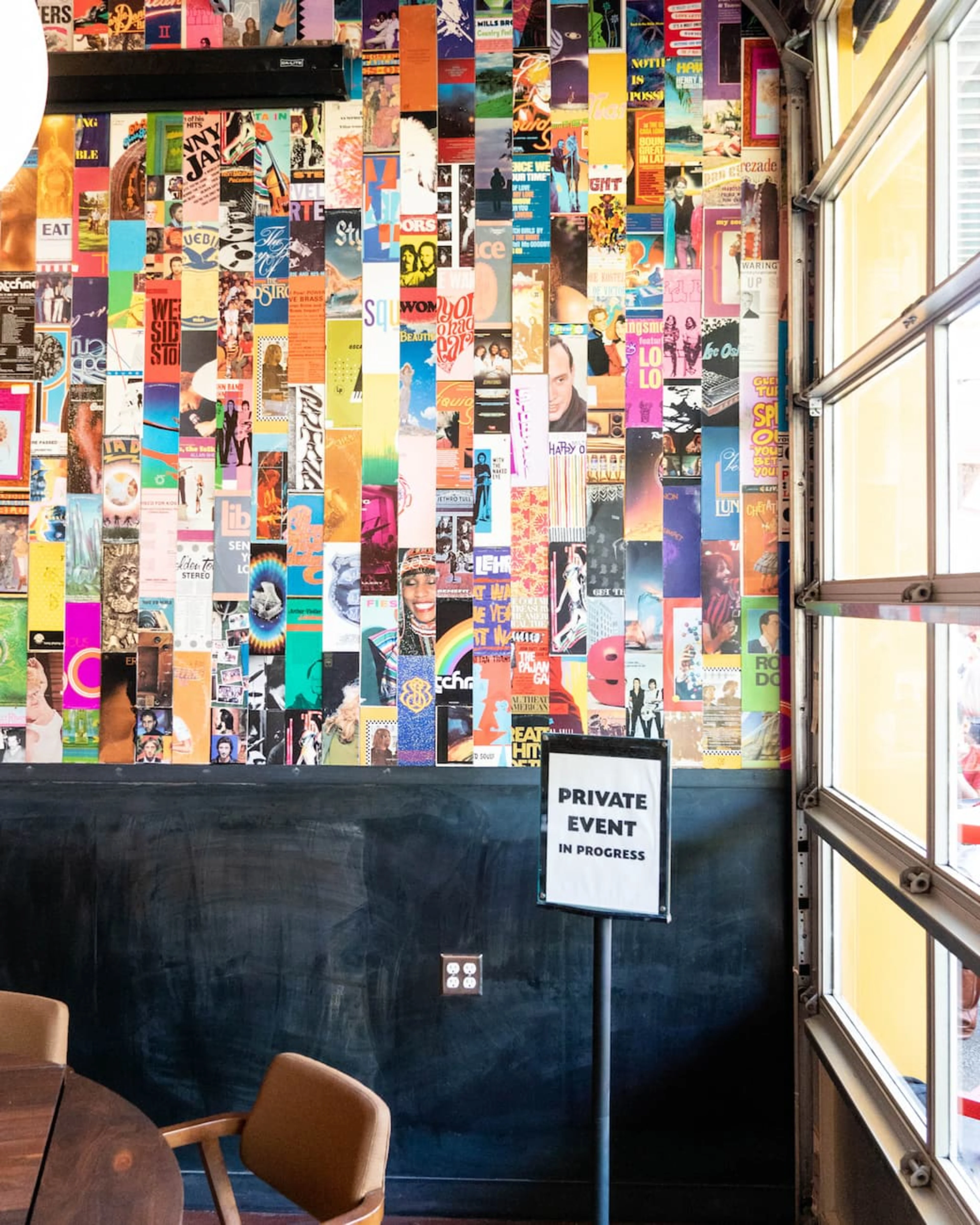 A colorful wall with a private event sign in front of it.