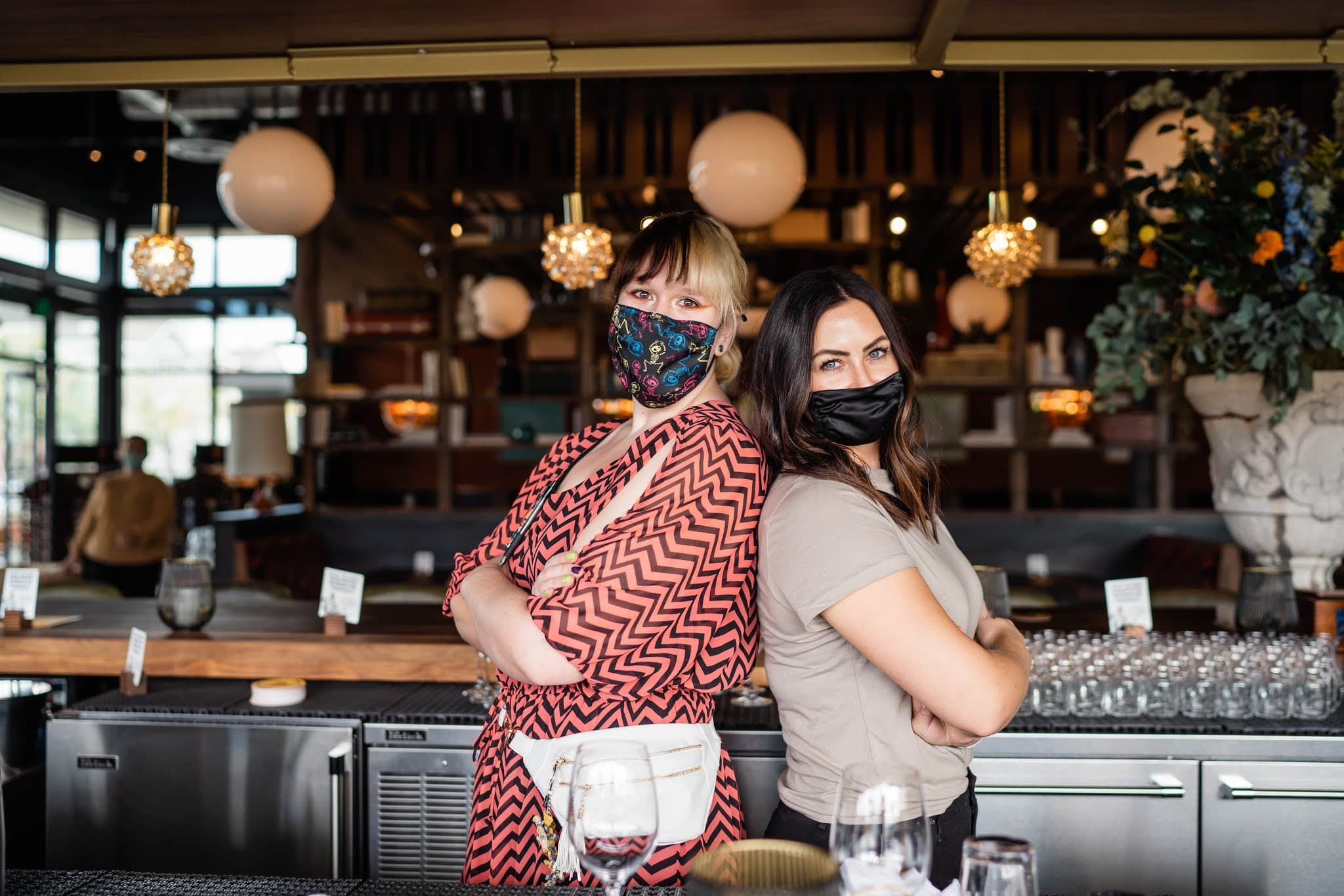 Servers wearing masks stand back to back
