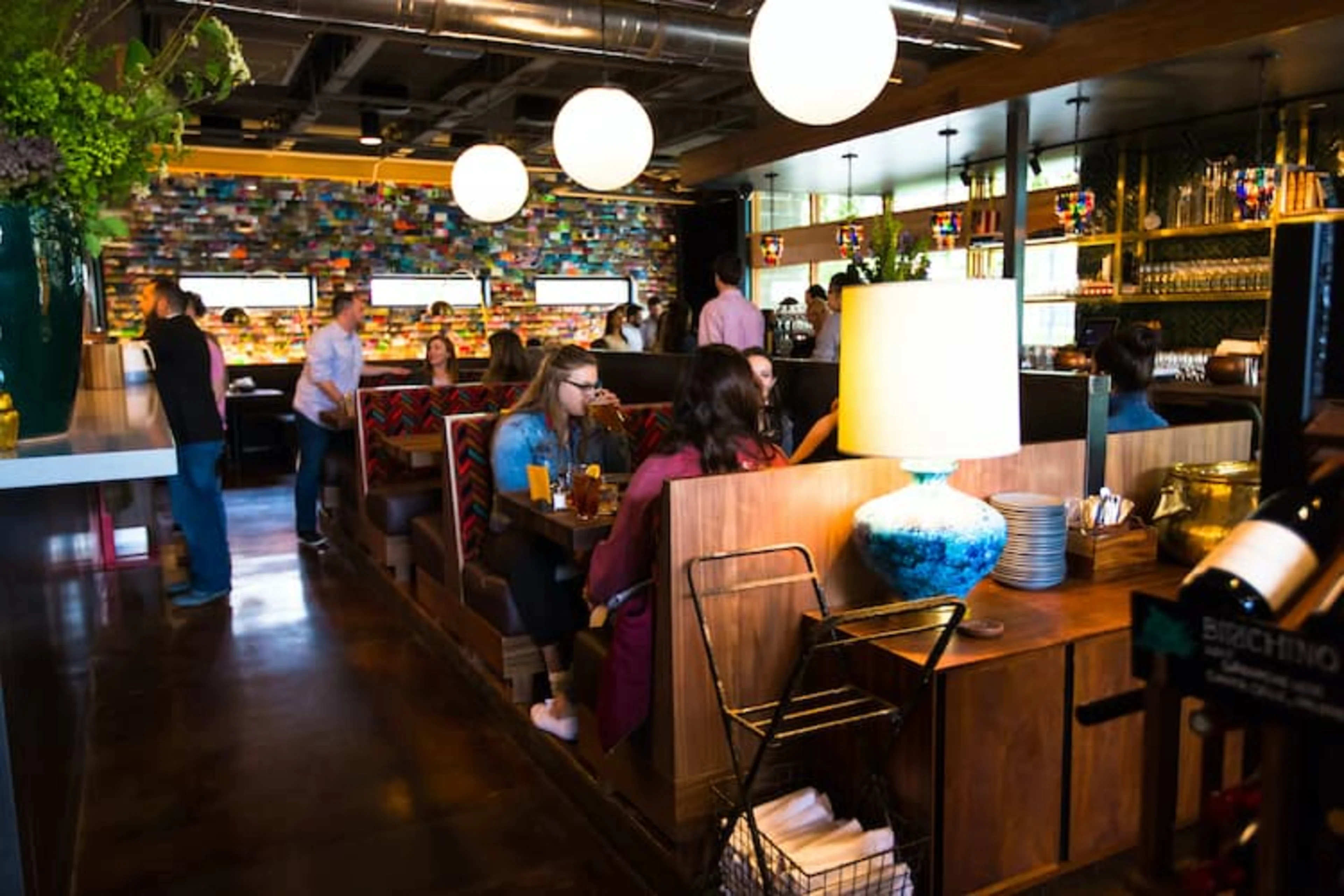 A busy restaurant with customers in booths.