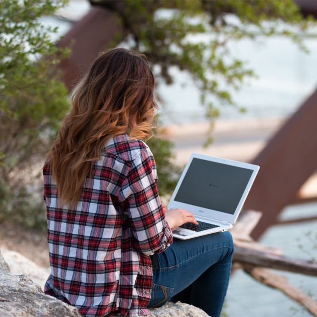 Girl studying on laptop outside