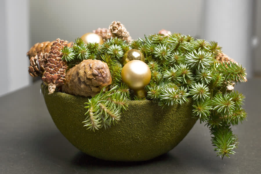 Stilfullt arrangemang med grönt, kottar och guldfärgade julkulor. Foto: Floradania