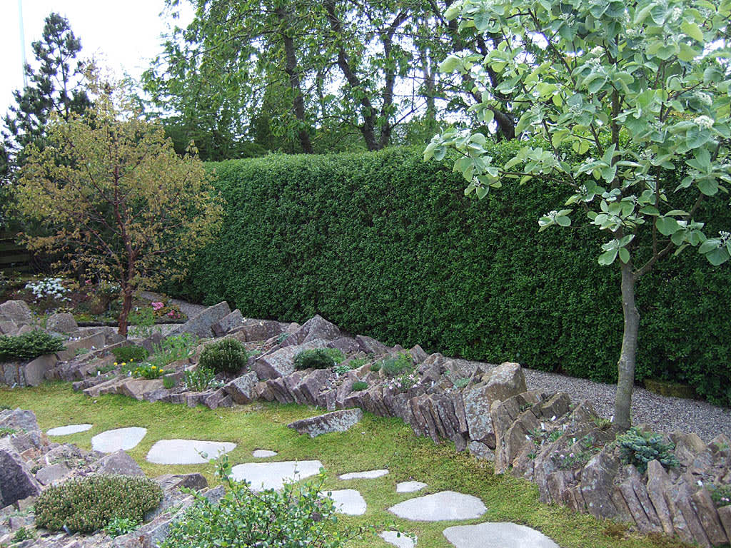 Platta, ojämna stenar bildar en avgränsningsmur som planterats. Foto: Bernt Svensson