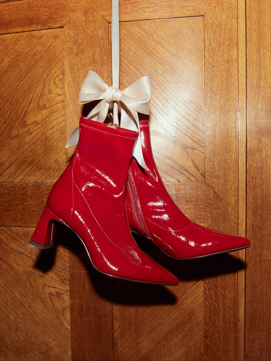 Bottines en cuir verni rouge à talon mi-haut ornées d'un nœud en satin blanc