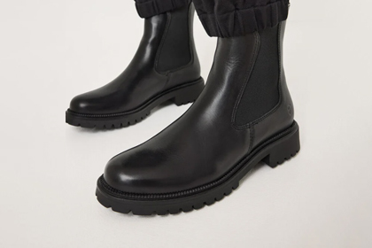 Bottines Chelsea en cuir noir avec semelle robuste sur fond blanc