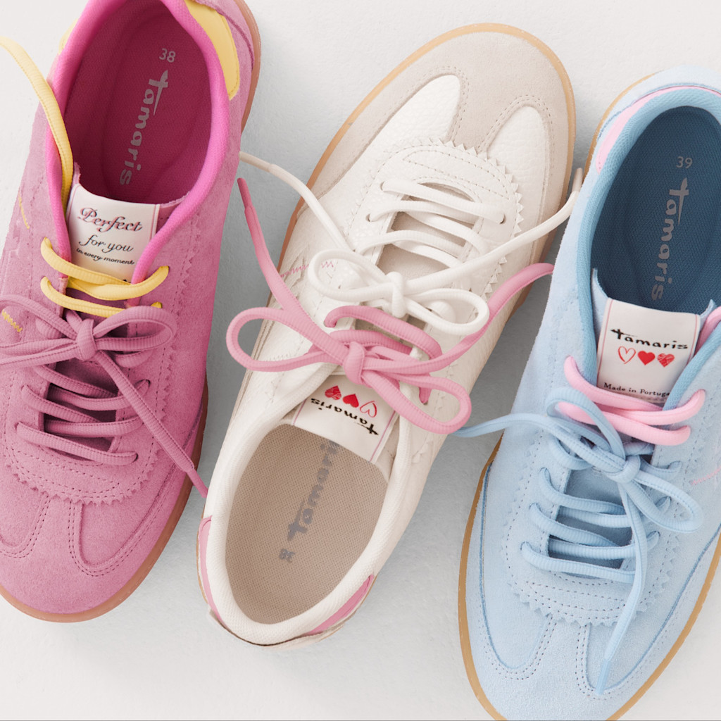 Tre sneakers Tamaris nei colori pastello &ndash; rosa, bianco e azzurro chiaro &ndash; con lacci coordinati su uno sfondo chiaro.
