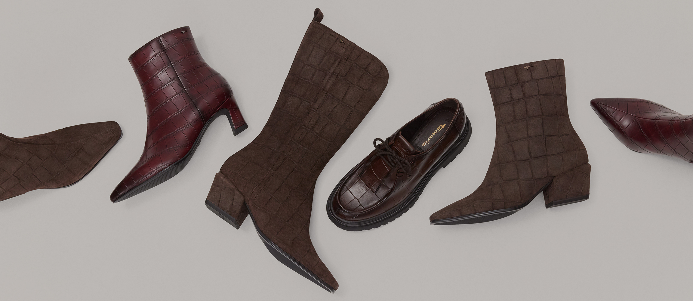Verschillende Tamaris‑schoenen in donkerbruin en bordeaux met krokoreli&euml;f, waaronder enkellaarsjes en een veterschoen.