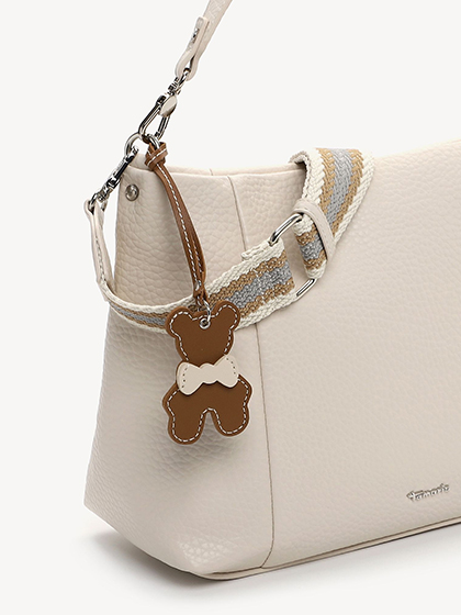 Beige handbag with a brown bear charm and silver details.