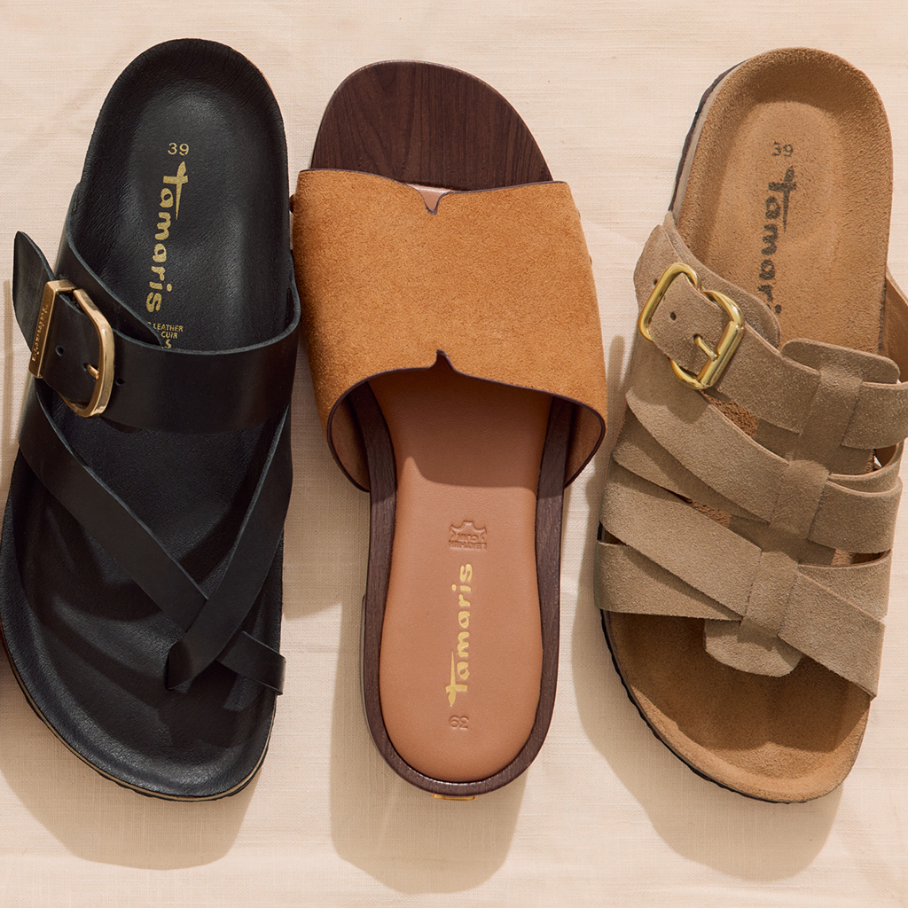 Vier Tamaris Sandalen in Braun, Beige, Schwarz und Cognac, nebeneinander auf hellem Untergrund platziert.