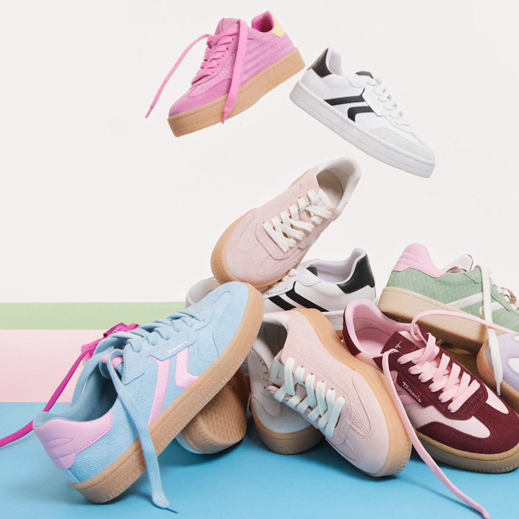 Sportliche Sneaker in Pastellfarben wie Rosa, Hellblau und Mint, mit weißen Schnürsenkeln und Gummisohlen auf blauem Hintergrund.