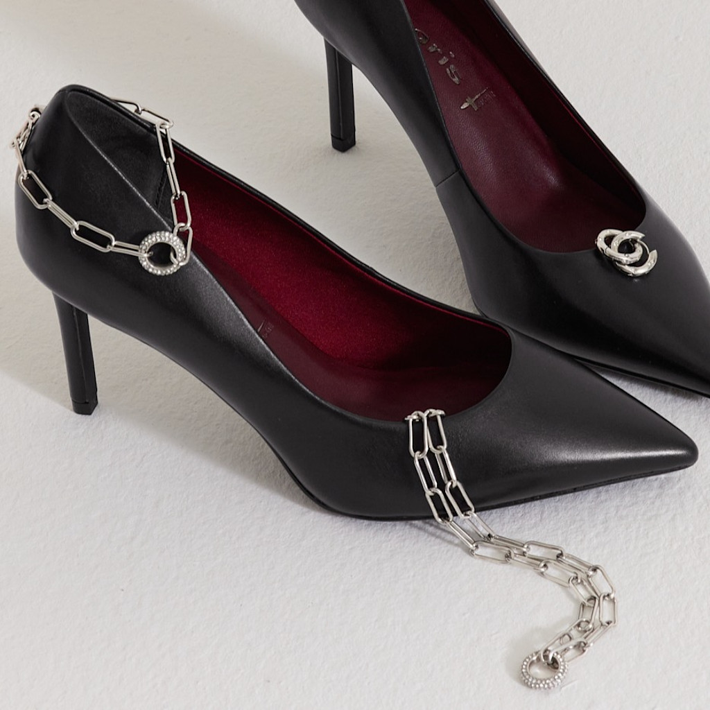 Black stilettos and silver jewelry on a white background