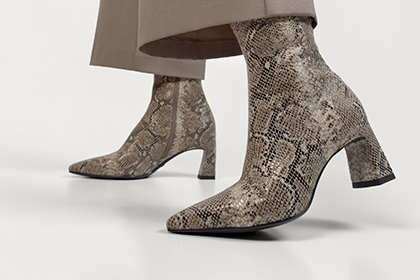 Elegante enkellaarsjes met slangenpatroon in grijs en beige op een blokhak.