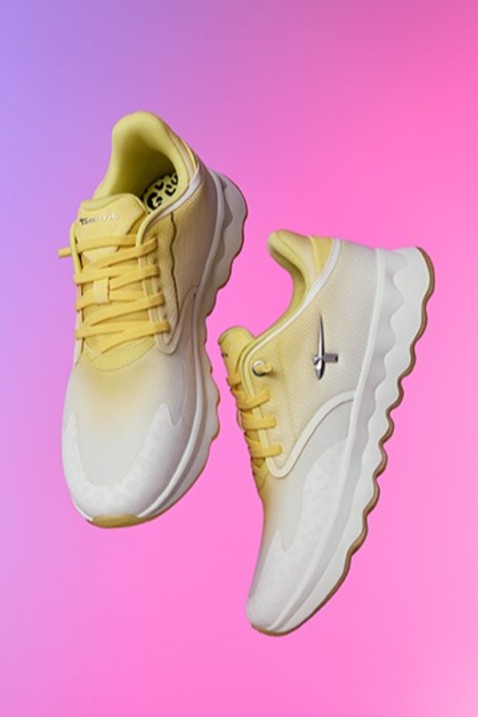 Chaussures de sport jaune et blanc avec d&eacute;grad&eacute; de couleurs flottant devant un fond rose-violet.