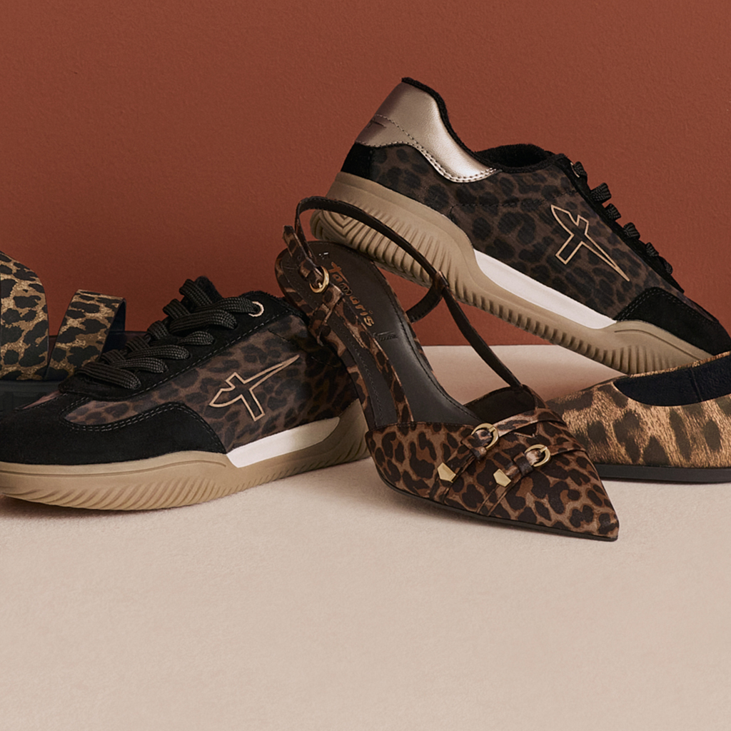 Sportliche Sneaker mit Leopardenmuster in Braun und Schwarz, mit T-Logo an der Seite, auf beigem Hintergrund.