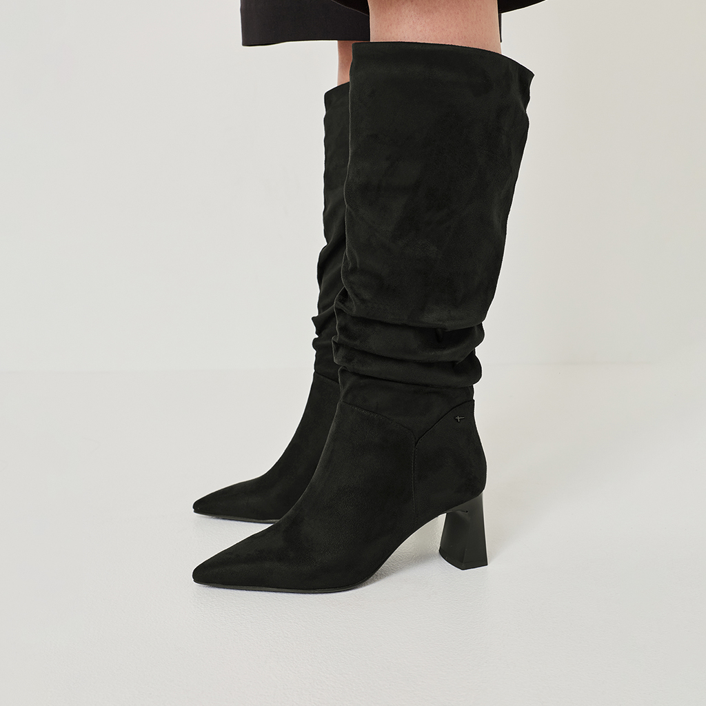 Schwarze Wildleder-Stiefel mit hohem Schaft und Blockabsatz, leicht gerafft, auf wei&szlig;em Hintergrund fotografiert.