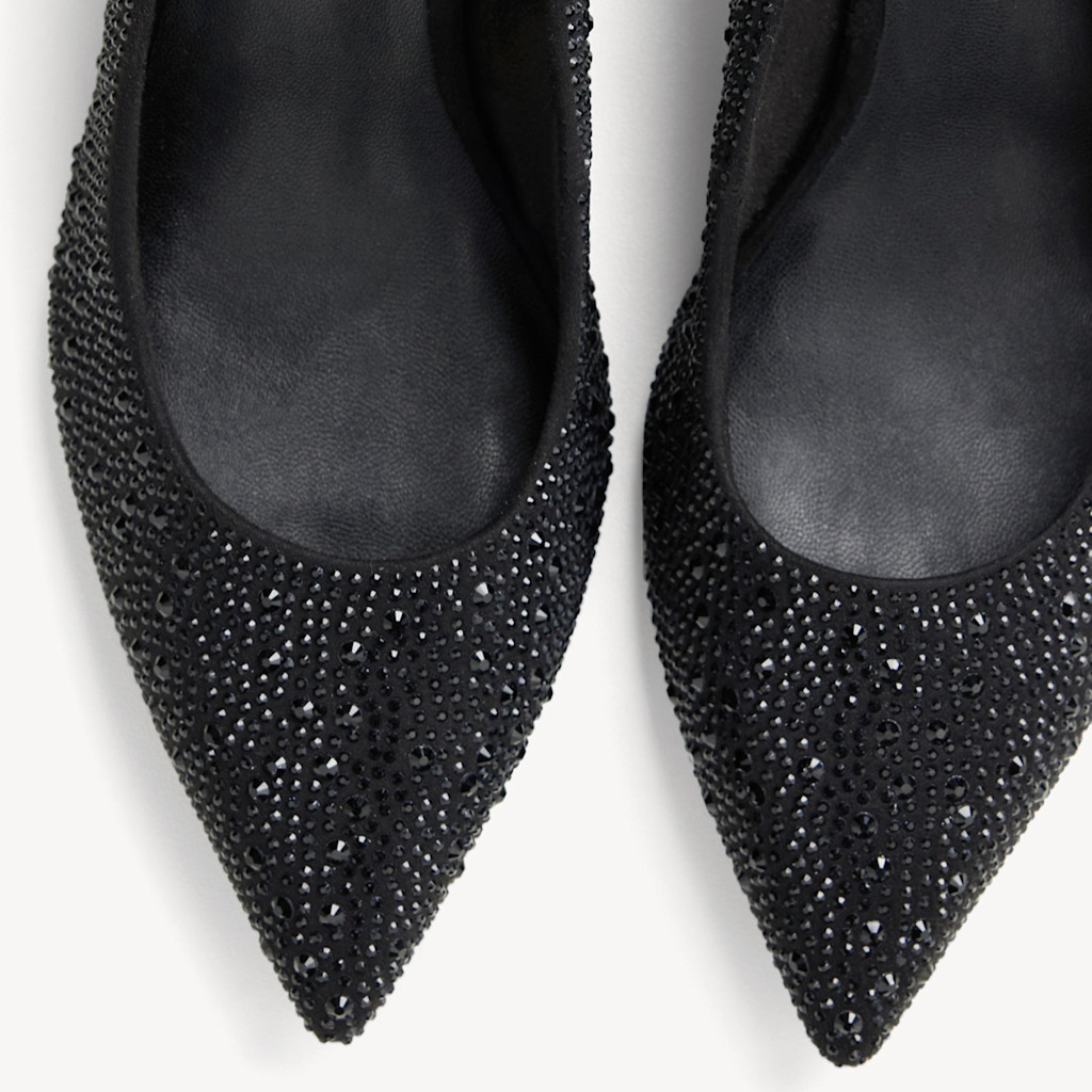 Schwarze Pumps mit glitzernden Kristallen verziert, spitze Form, auf wei&szlig;em Hintergrund fotografiert