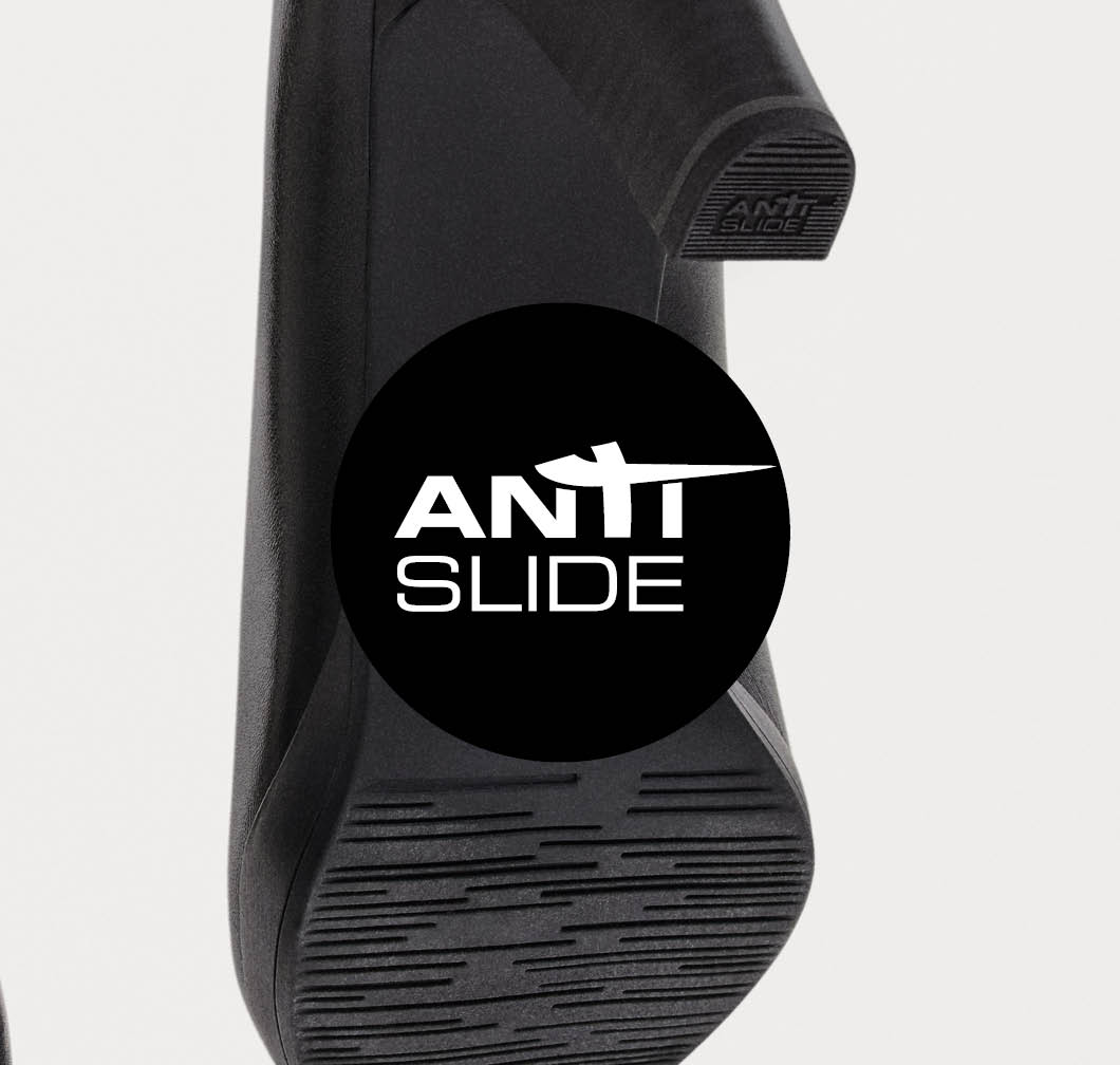 Underside of a black pump with a non‑slip treaded sole and an Anti‑Slide logo in a black circle.