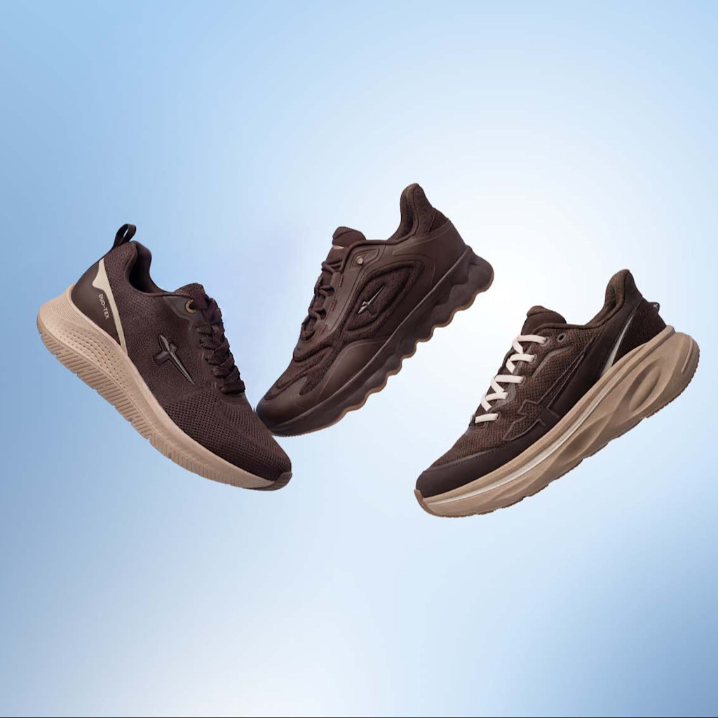 Three brown trainers with light-coloured soles are floating against a light blue background.
