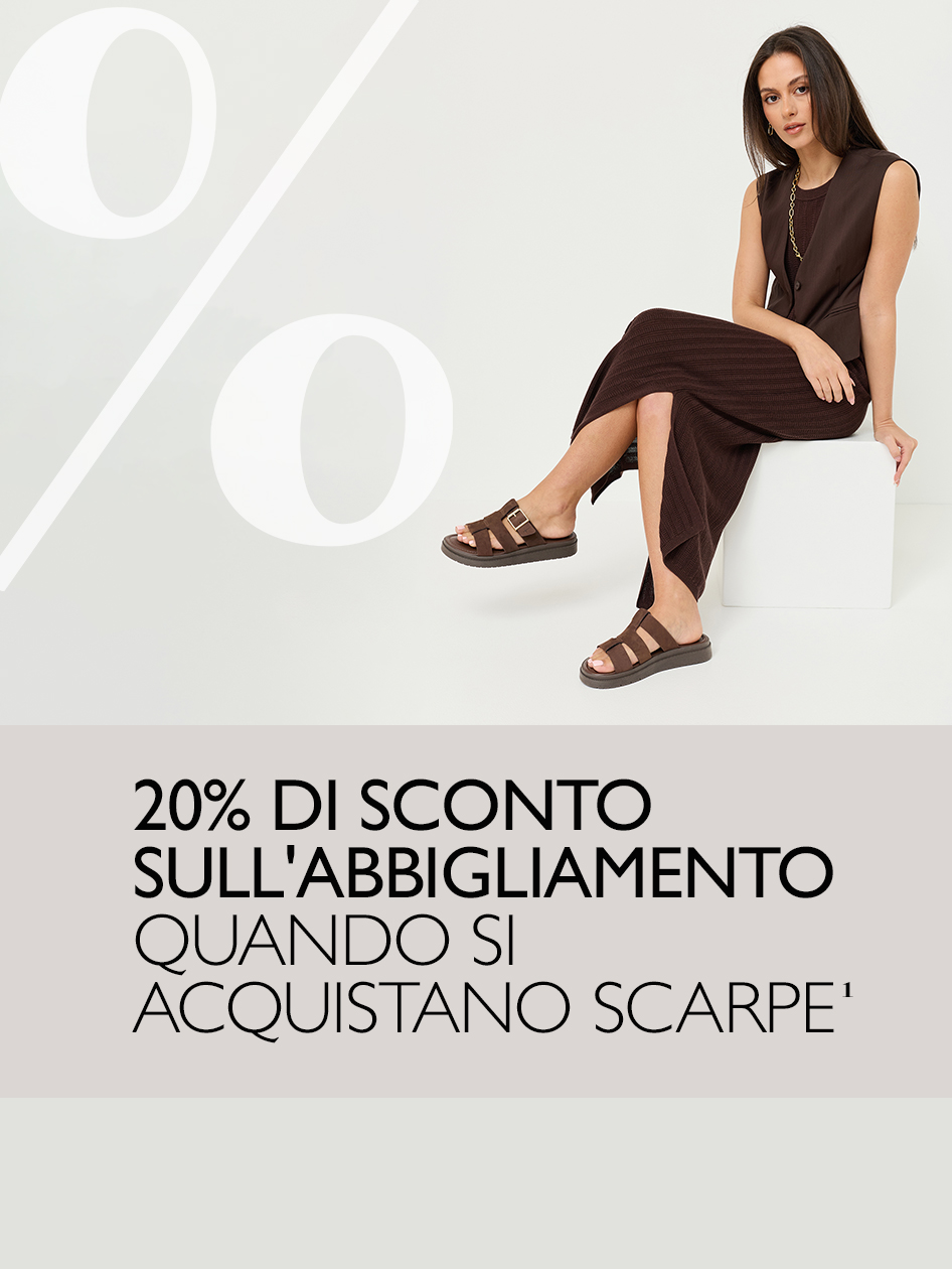 Donna con outfit marrone e sandali seduta su un cubo bianco. Offerta: 20% sull&rsquo;abbigliamento con l&rsquo;acquisto di scarpe.
