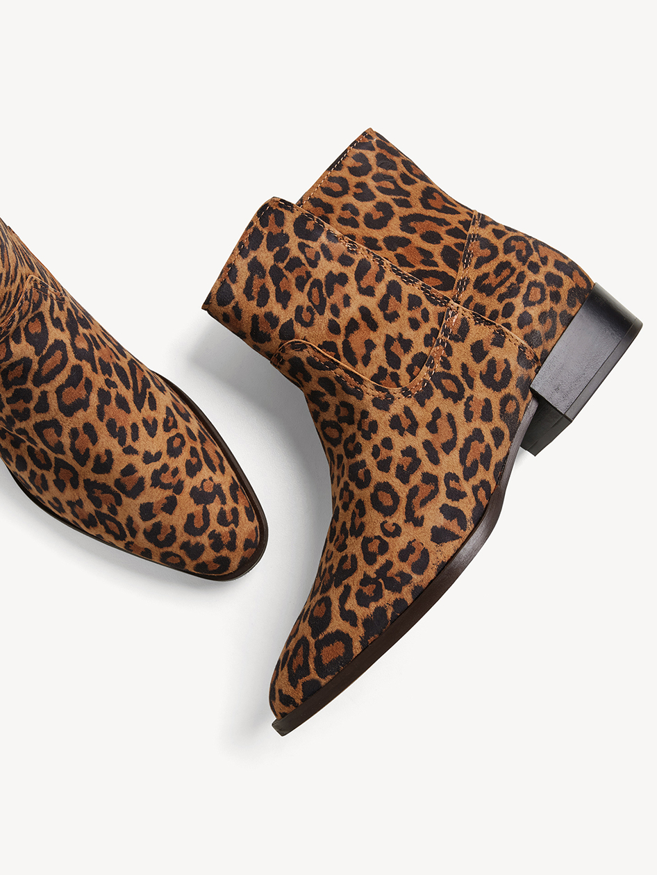 Short ankle boots with leopard print made of suede, flat heel on a white background.