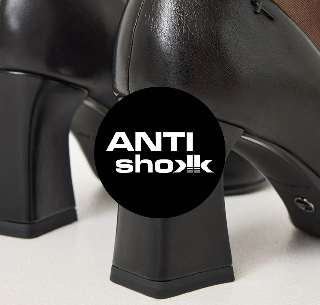 Black leather pumps with a block heel, close‑up of the heel with an Anti‑Shock logo in a black circle.