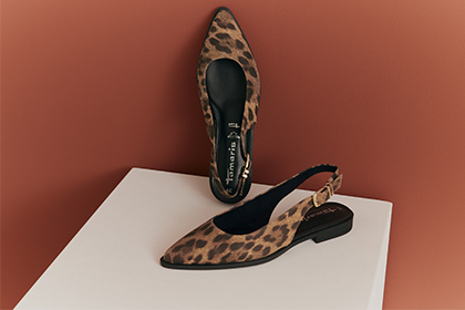 Escarpins slingback Tamaris &agrave; motif l&eacute;opard sur un socle blanc devant un fond couleur terracotta.