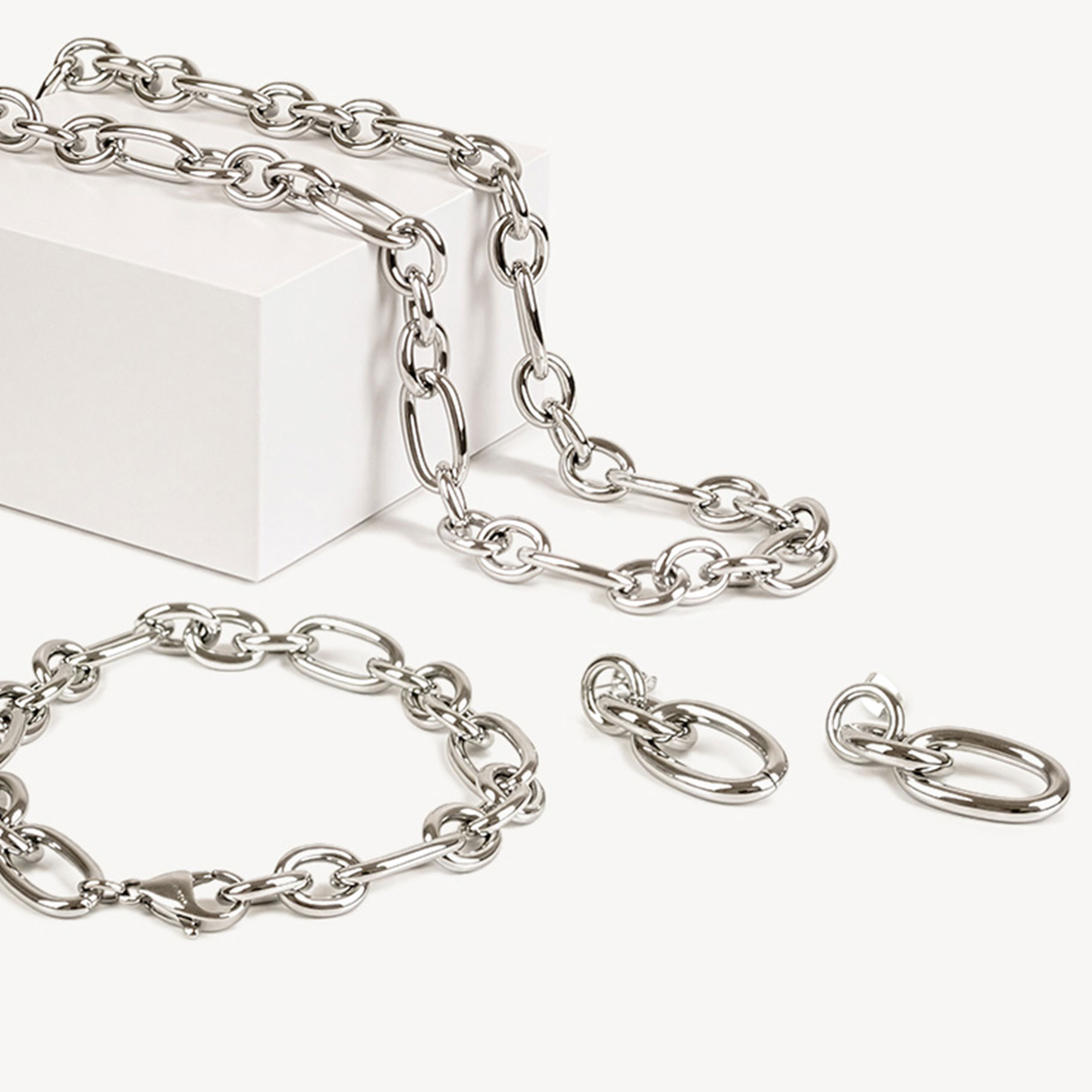 Collier &agrave; maillons argent&eacute;s avec &eacute;l&eacute;ments ovales et ronds sur fond blanc.