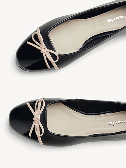 Ballerines en cuir verni noir avec n&oelig;ud rose.