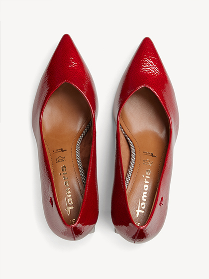 Glanzende rode lakleren pumps met spitse vorm, van bovenaf gefotografeerd.