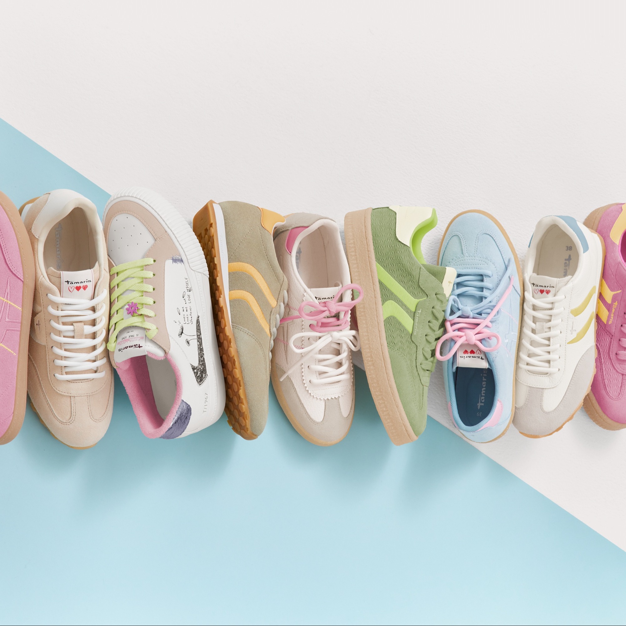 Ensemble de baskets aux couleurs pastel comme le rose, le bleu clair et le vert menthe, enfil&eacute;es sur fond bleu clair