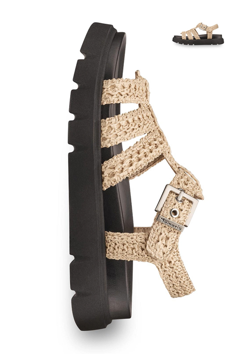 Tamaris sandal with beige crocheted straps, black treaded sole and silver buckle against a white background.