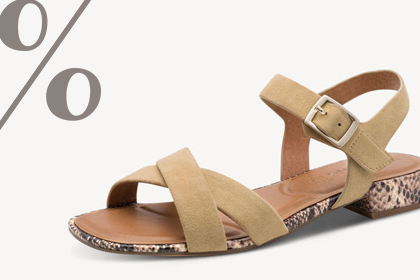 Beige sandal with crossover straps, ankle strap and buckle, snake‑print heel, on a light background with a percent sign.