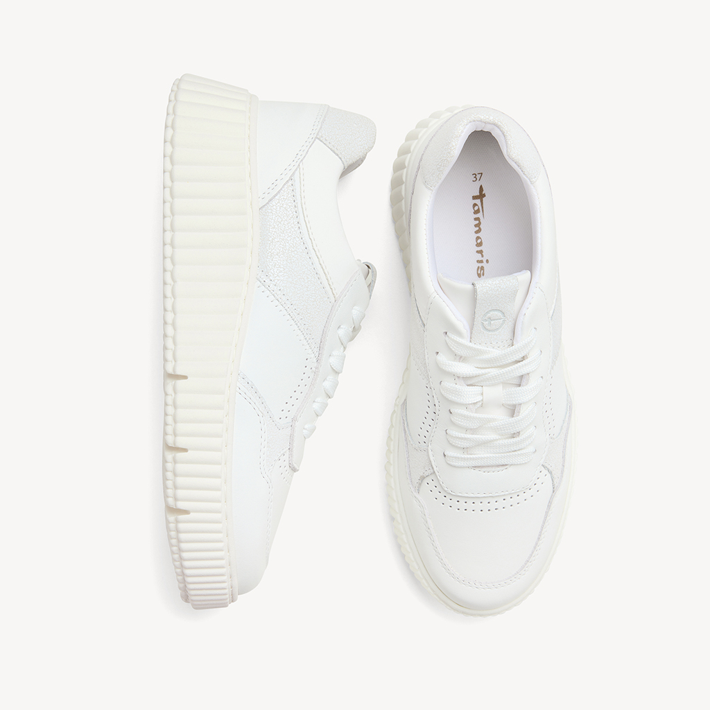 Weiße Sneaker mit robuster Profilsohle und Schnürsenkeln, fotografiert auf weißem Hintergrund