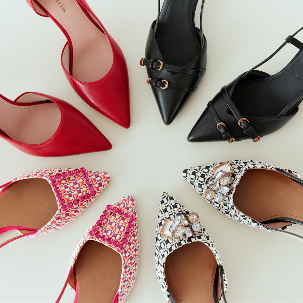 Elegante damesko: r&oslash;de pumps, sorte remsko og dekorerede ballerinaer i pink og sort-hvid p&aring; lys baggrund.