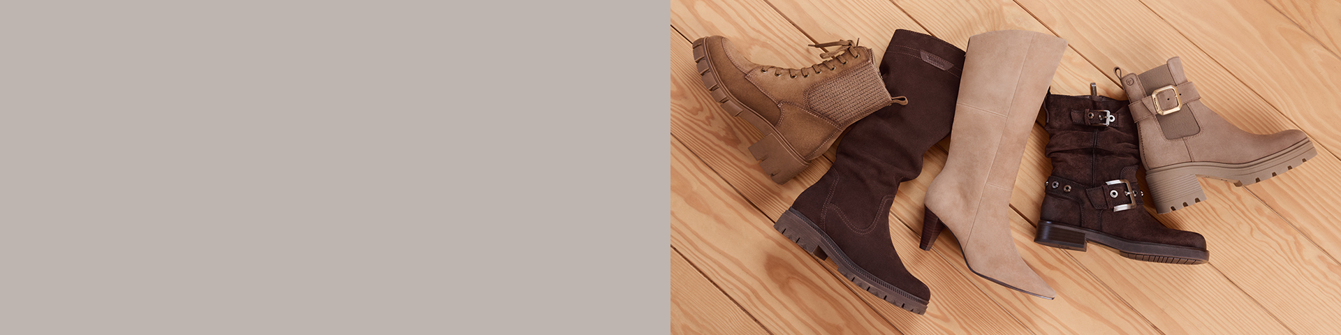 Various women's boots in brown and beige tones on a light wooden floor, arranged diagonally.