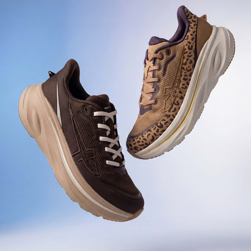 Twee zwevende sneakers: &eacute;&eacute;n in donkerbruin met een beige zool, &eacute;&eacute;n met luipaardprint en paarse accenten, voor een blauwe achtergrond.