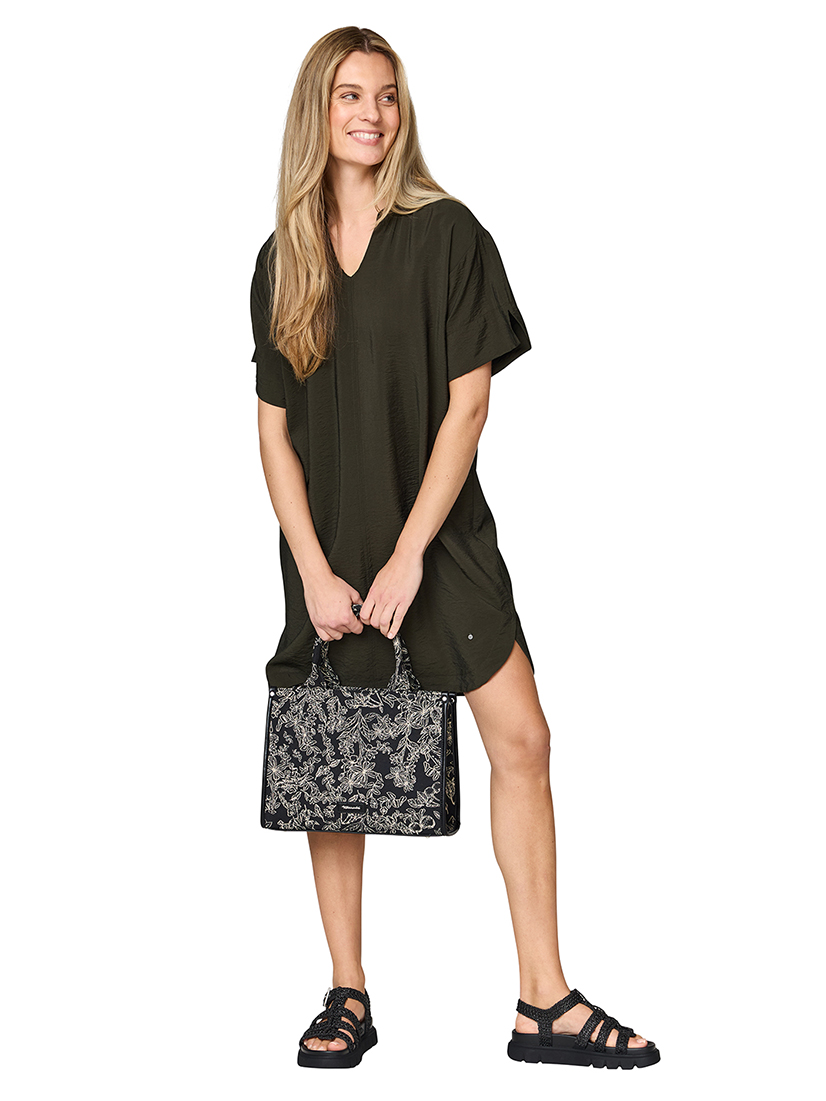 Donna con abito verde oliva a maniche corte e scollo a V, tiene in mano una borsa nera a fantasia e indossa sandali neri.